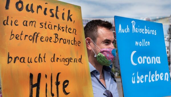 Pressefotos Touristik braucht Hilfe Demonstrant mit Mundschutz und Plakaten